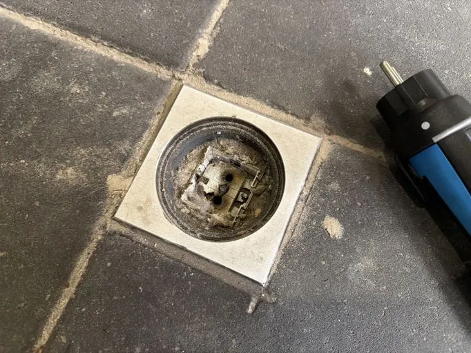 Doorgebrande wandcontactdoos in een vloerpot zonder klep